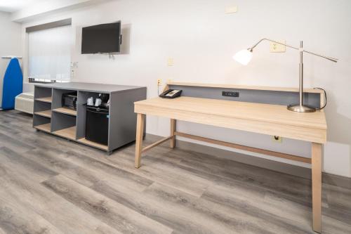 an office with a desk and a tv on a wall at Country Inn & Suites by Radisson, Stone Mountain, GA in Stone Mountain