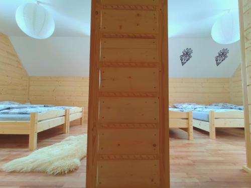 a room with two beds and a ladder in it at Góralskie Domki na Podhalu - z jacuzzi in Maniowy