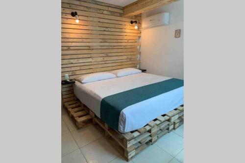 a bed in a room with a wooden wall at NUEVO Estudio en Playas Vicente Fox. ¡Excelente ubicación! in Boca del Río