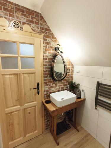 a bathroom with a white sink and a mirror at Góralskie Domki na Podhalu - z jacuzzi in Maniowy