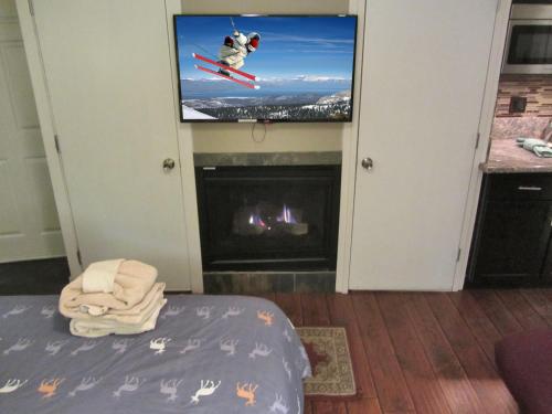 a living room with a tv and a fireplace at Gondola Lodge & Tahoe Beach Club in South Lake Tahoe