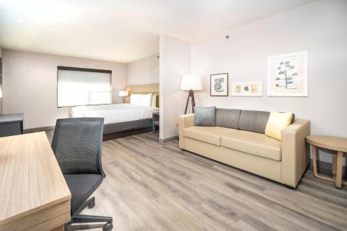 a hotel room with a couch and a bed at Country Inn & Suites by Radisson, Stone Mountain, GA in Stone Mountain