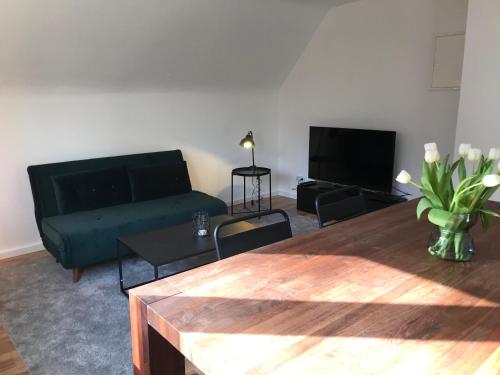 ein Wohnzimmer mit einem Sofa und einem TV in der Unterkunft Apartment Frankfurt, top renoviert, 65qm DG in Bergisch Gladbach