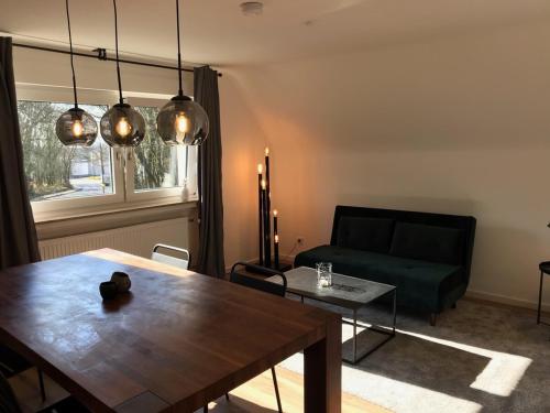 sala de estar con mesa y sofá verde en Apartment Frankfurt, top renoviert, 65qm DG, en Bergisch Gladbach