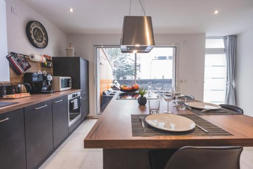 a kitchen with a table with wine glasses on it at La Source d'Arbère in Divonne-les-Bains