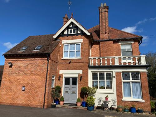 a red brick house with a white at Fairlawns Guest House in Banbury