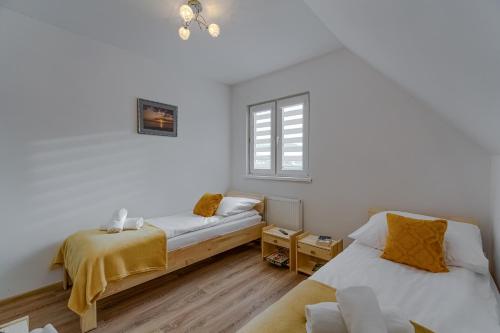 sypialnia z dwoma łóżkami i oknem w obiekcie Apartament na Sportowej w mieście Tylicz