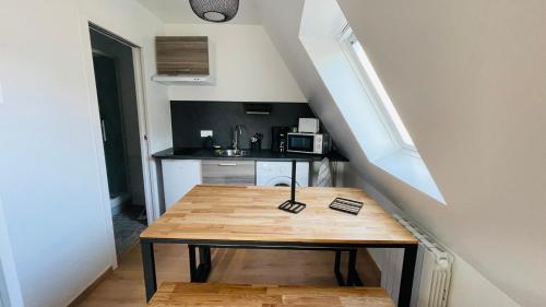 une petite cuisine avec une table en bois dans une pièce dans l'établissement A la Clef - Charmant studio proche gare et centre - Idéal PRO & Couple - WIFI, au Mans