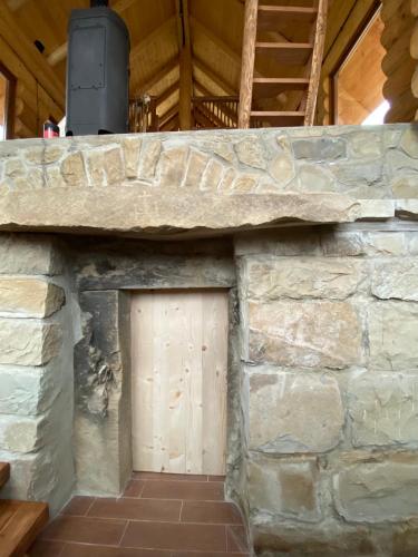 a stone wall with a wooden door in it at Chalet PidStromom in Mykulychyn
