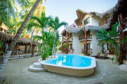 a large swimming pool in a tropical setting at Holbox Dream Beachfront Hotel in Holbox Island