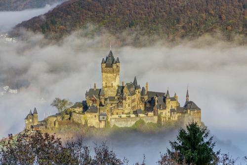 a castle on a hill in the clouds at Ferienwohnung Luna in Cochem