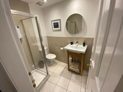 uma casa de banho com um WC, um lavatório e um espelho. em Angel Mews - Heart of the West End Near Glasgow University em Glasgow