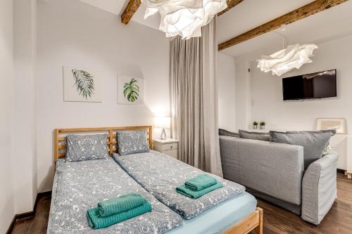 グリヴィツェにあるApartament Szczęśliwa Trzynastkaのベッドルーム(ベッド1台、ソファ付)