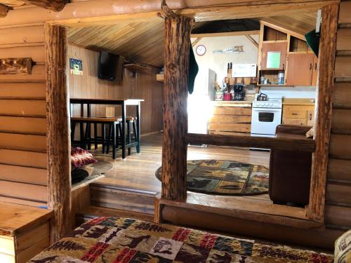 ein Wohnzimmer und eine Küche in einem Blockhaus in der Unterkunft Riverbend Resort in South Fork