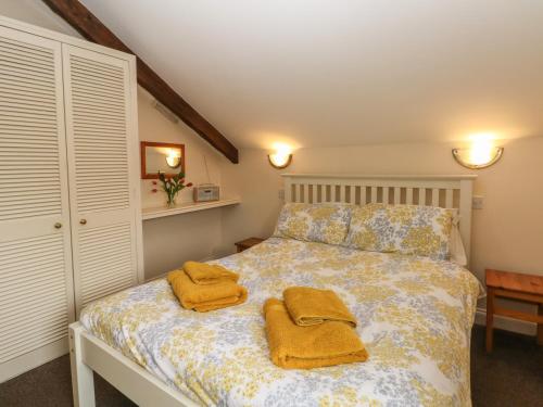a bedroom with a bed with two towels on it at The Loft in Buxton