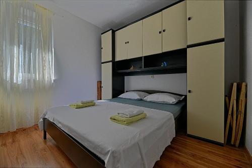 Schlafzimmer mit einem Bett mit weißen Schränken in der Unterkunft Apartments Puli - 200m from sea in Postira