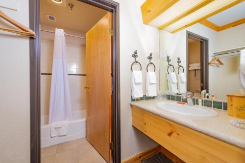 a bathroom with a sink and a mirror at Schweitzer Mountain Resort Selkirk Lodge in Sandpoint