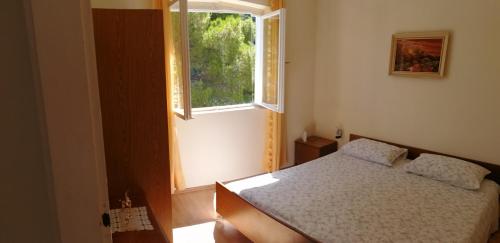 a bedroom with a bed and a window at Holiday home Dob - 5m from the sea in Kut