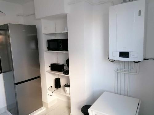 une cuisine équipée d'un réfrigérateur et d'un téléphone sur une étagère. dans l'établissement SWEET Appartment avec Wifi et parking, à Clermont-Ferrand