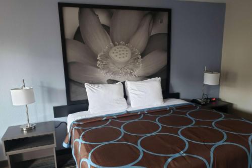 a bedroom with a bed with a large picture on the wall at Super 8 by Wyndham Morganton in Morganton
