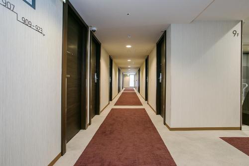 a long corridor with a red carpet in a building at Mars Garden Hotel Hakata in Fukuoka