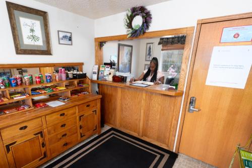 a woman is sitting at a counter in a store at Cold Creek Inn in Mount Shasta