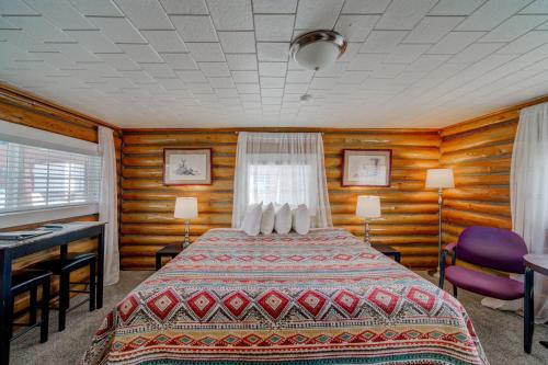 A bed or beds in a room at Sportsman's Lodge