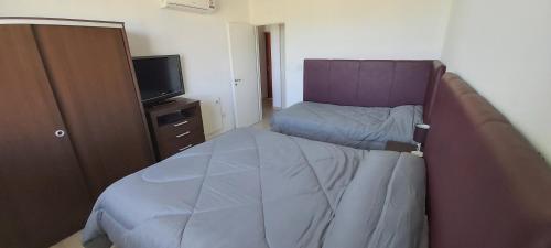 1 dormitorio pequeño con 1 cama y TV en Torre Orca Piso 9 Mareas del Golfo en Las Grutas