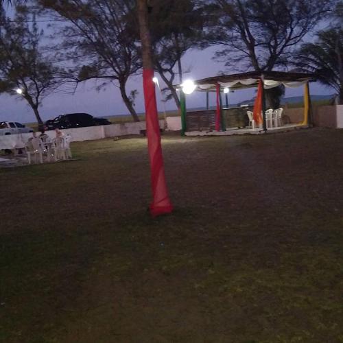 a red pole in the middle of a park at night at Pousada Cataventos in Sirinhaém