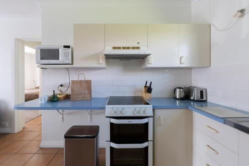 a kitchen with white cabinets and a blue counter top at Forrest Hotel & Apartments in Canberra