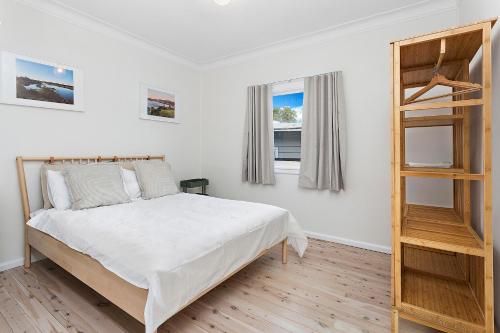 a bedroom with a bed and a book shelf at Mystics Beach Bungalows in Minnamurra
