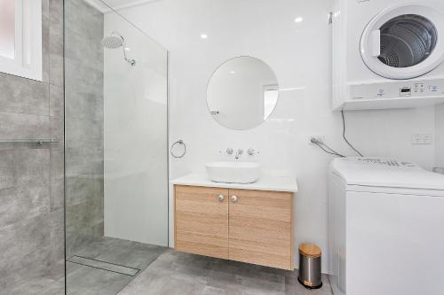 a bathroom with a sink and a shower at Mystics Beach Bungalows in Minnamurra