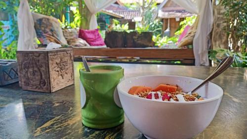 eine Schüssel mit Essen auf einem Tisch mit einem Getränk in der Unterkunft Santhiku Hotel & SPA in Lovina