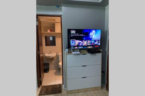 a bathroom with a tv on top of a dresser at Anuva Condominium with Netflix in Manila
