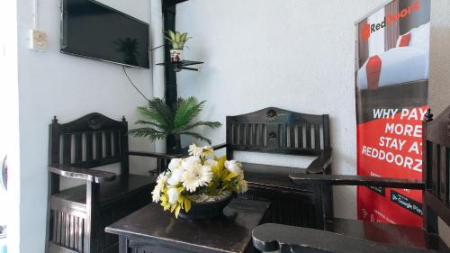 a dining room with a table with flowers on it at RedDoorz Plus Villa Gloria Taguig in Manila