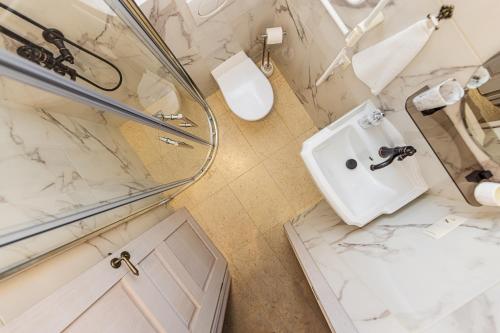 a white bathroom with a toilet and a sink at Sakura_INN Palanga in Palanga