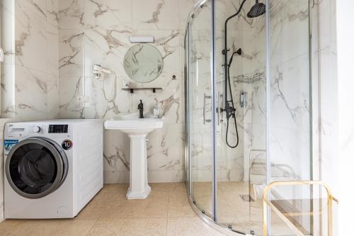 a bathroom with a shower and a washing machine at Sakura_INN Palanga in Palanga