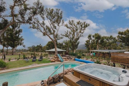 a pool with a hot tub in a yard at Banksia Park Cottages in Kangaroo Valley