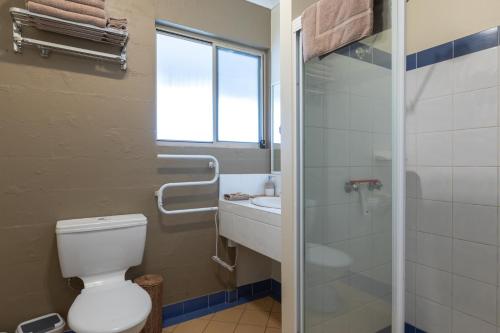 a bathroom with a toilet and a sink and a shower at Banksia Park Cottages in Kangaroo Valley