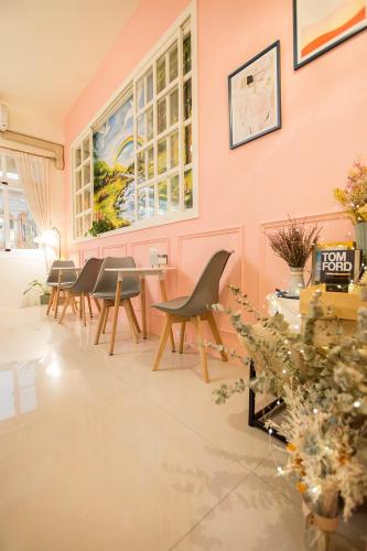 a dining room with chairs and a table and a wall at Square B&B in Taitung City