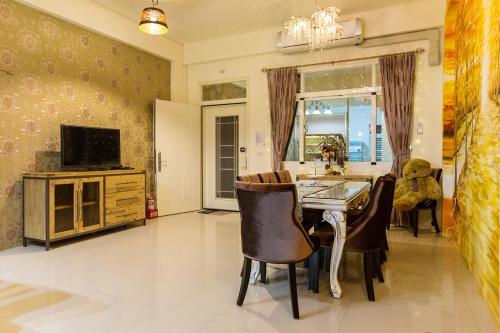 a kitchen with a table and chairs and a television at Square B&B in Taitung City