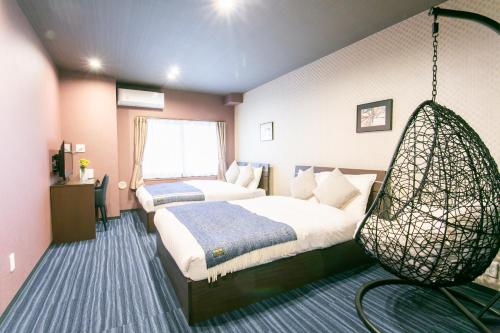 ein Schlafzimmer mit 2 Betten und einer hängenden Schaukel in der Unterkunft PLAYSIS Asakusa in Tokio