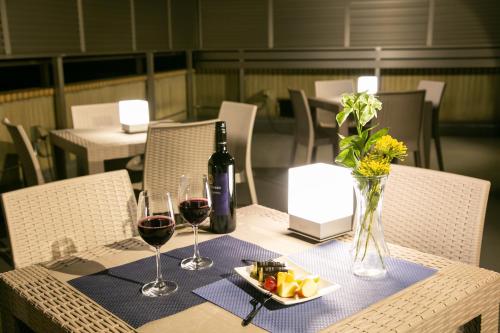 東京的住宿－PLAYSIS Asakusa，一张桌子,上面放着两杯葡萄酒和一盘食物