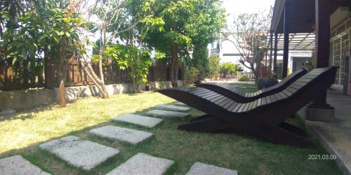 a bench sitting on the grass in a yard at 花宿 民宿 in Xiaoliuqiu