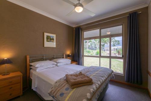 Tempat tidur dalam kamar di Banksia Park Cottages