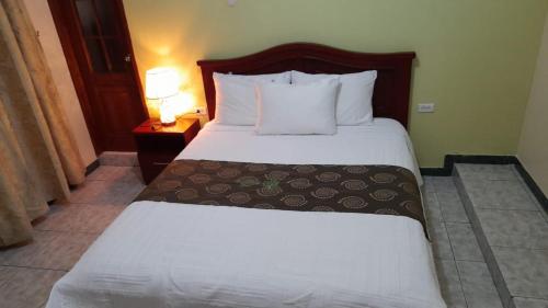 a bedroom with a large bed with white sheets and pillows at D’ RUIZ HOTEL in Quevedo