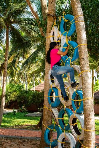 a woman climbing up a tree on a spiral staircase at GoGo Land Resort & Adventurous Sports in Pūvār