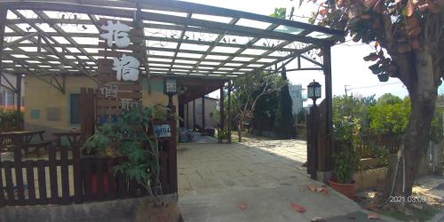 a pergola over a walkway in front of a building at 花宿 民宿 in Xiaoliuqiu