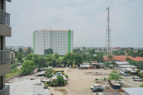 a large parking lot in front of a tall building at Gaudy Studio at Baileys Apartment by Travelio in Pondokcabe Hilir