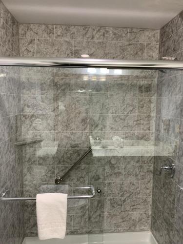 a bathroom with a shower with a glass door at Blue Bay Inn and Suites in South Padre Island